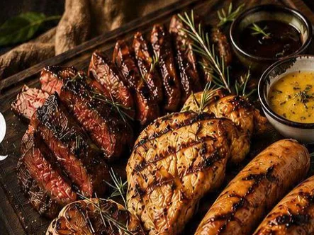 A grill board of sliced beef steak, grilled chicken and sausages with rosemary and two sauces